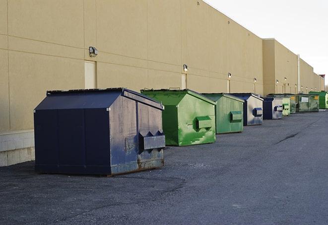 construction workers loading debris into dumpsters on a worksite in Doraville, GA